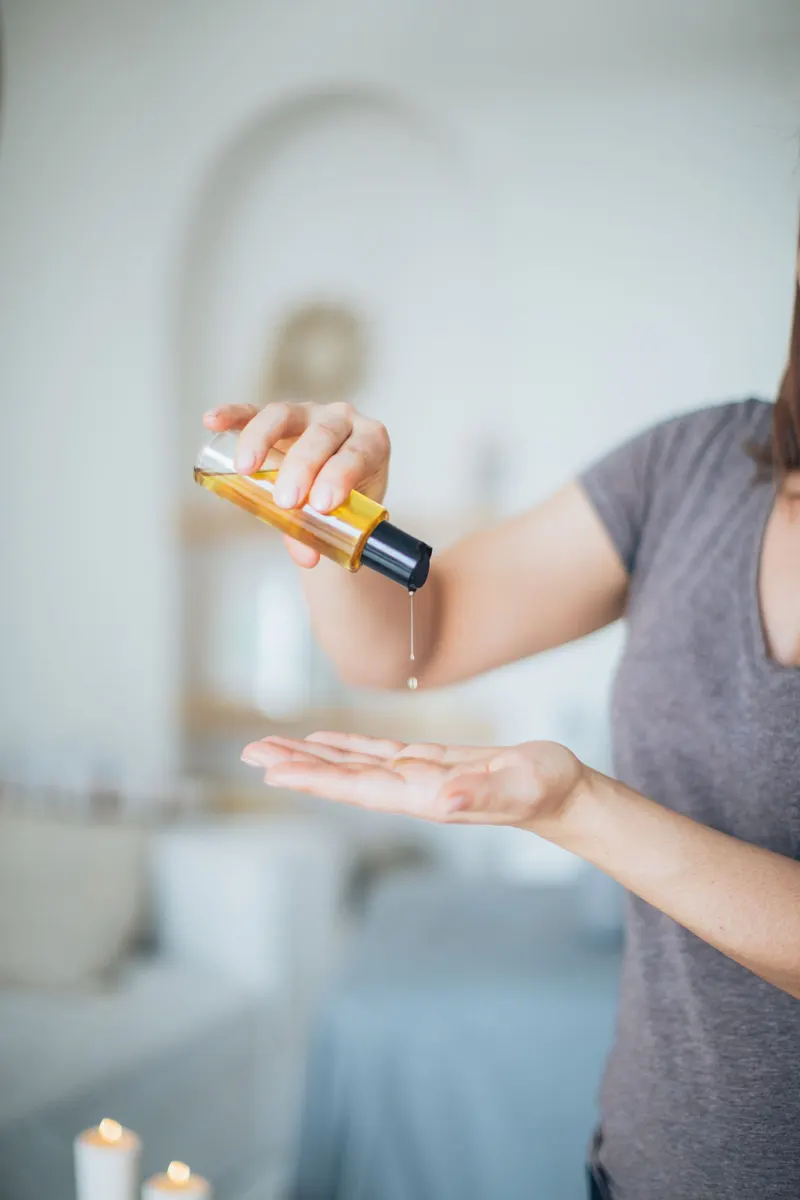Warme massageolie die in een hand druppelt